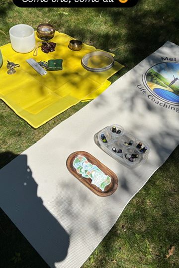 A workshop setup with sound bowls and oils laid out on a mat